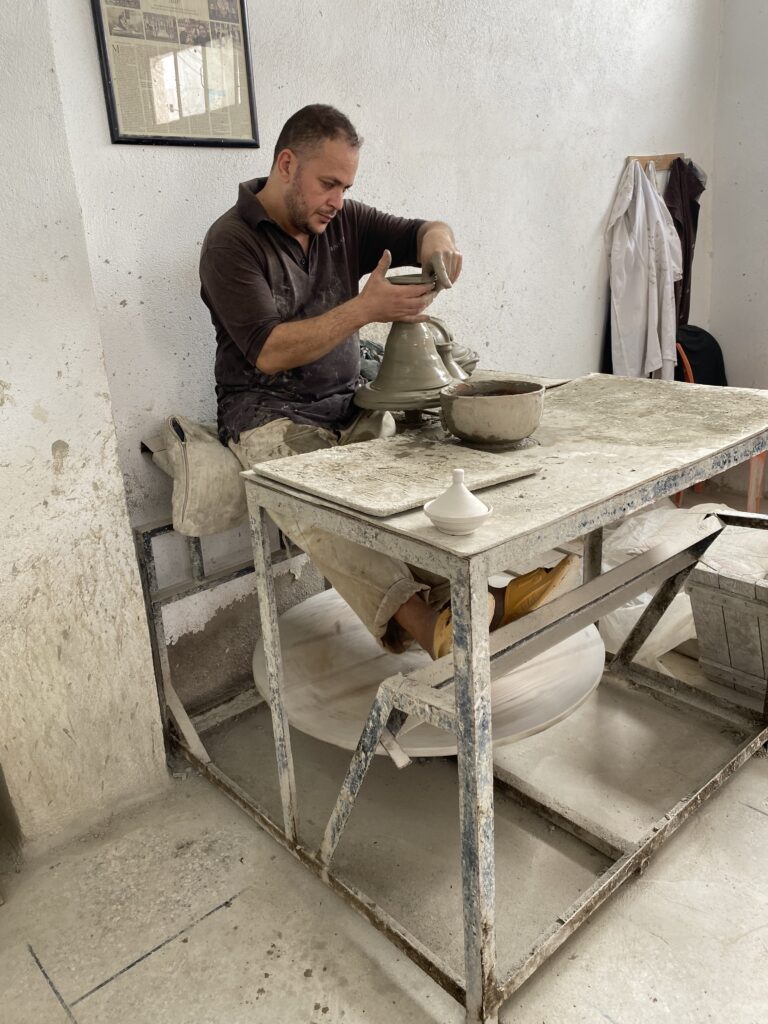 Man forming clay in a pottery workshop in Fes Morocco