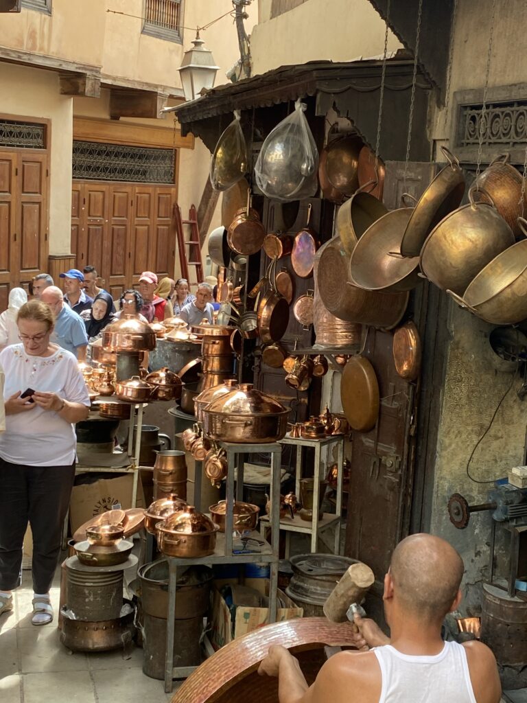Copper metalware being sold and hammered in Fez Morocco medina