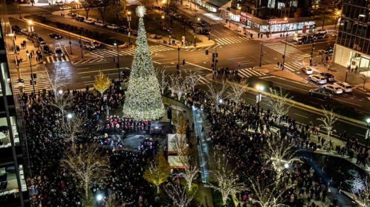 Tall Christmas tree in Washington DC surrounded by a crowd and holiday lights