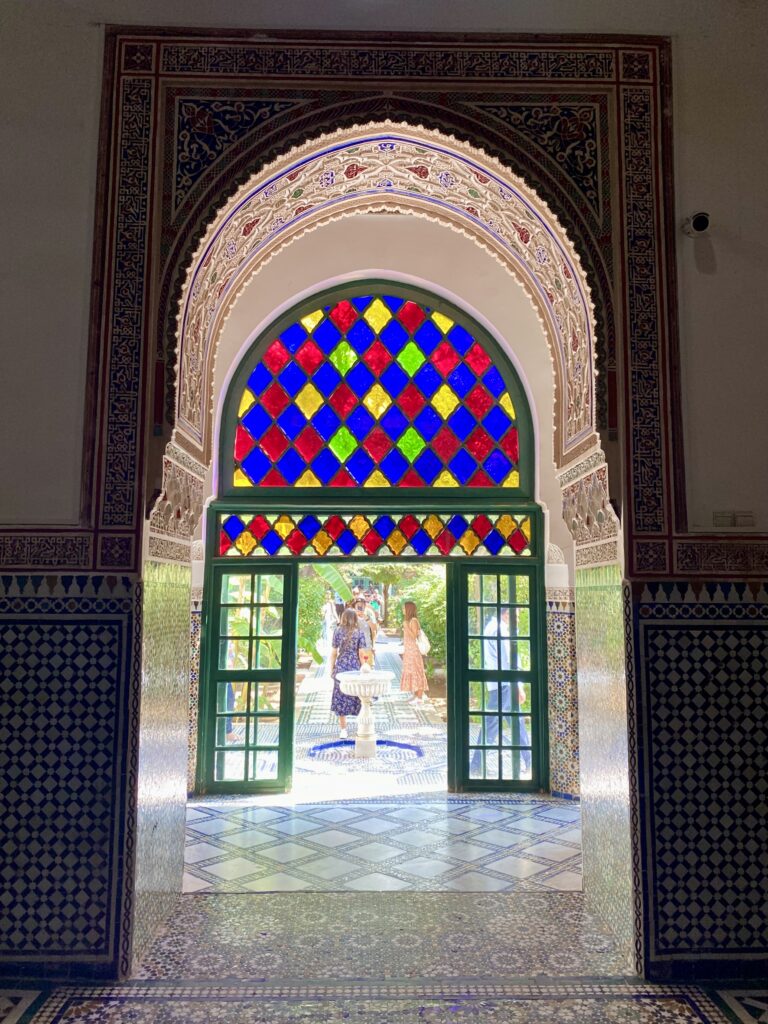 View of outdoor courtyard through palace door topped with stained glass