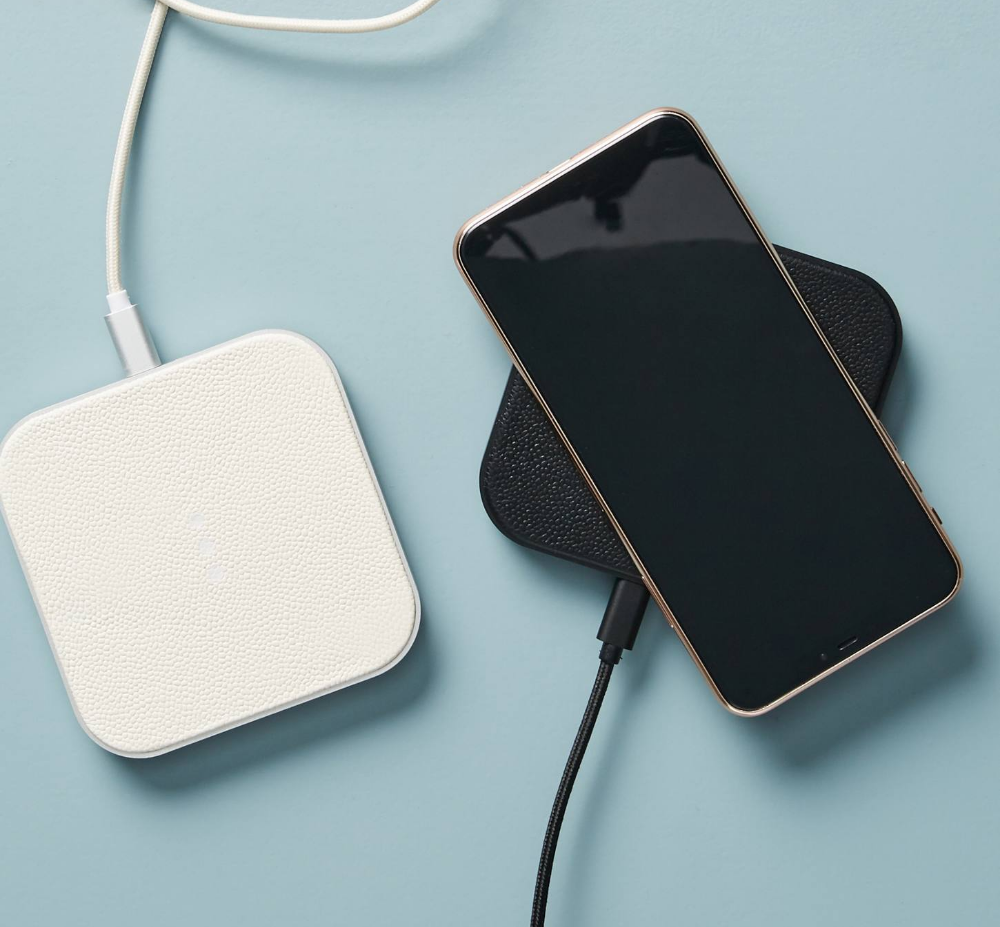 Two square portable phone chargers with a cell phone placed on top of one