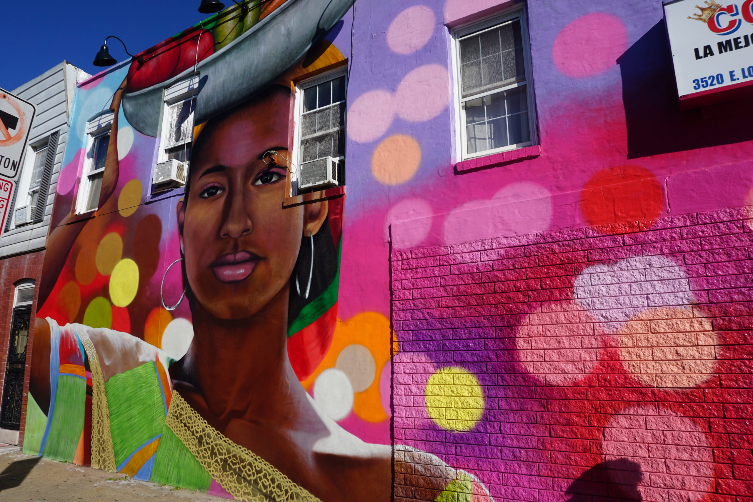 Colorful street mural of woman holding fruit basket