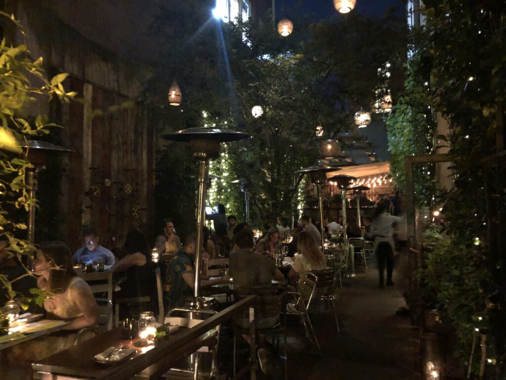 Outdoor dining patio at night with fairy lights overhead
