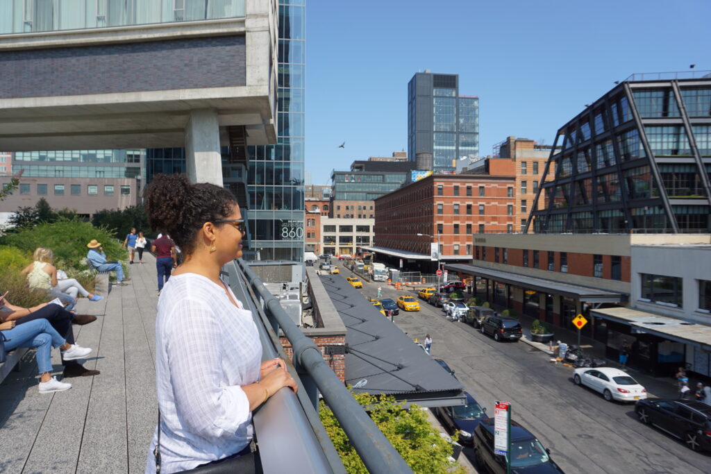 Woman standing on an elevated walkway looking out onto a New York City street
