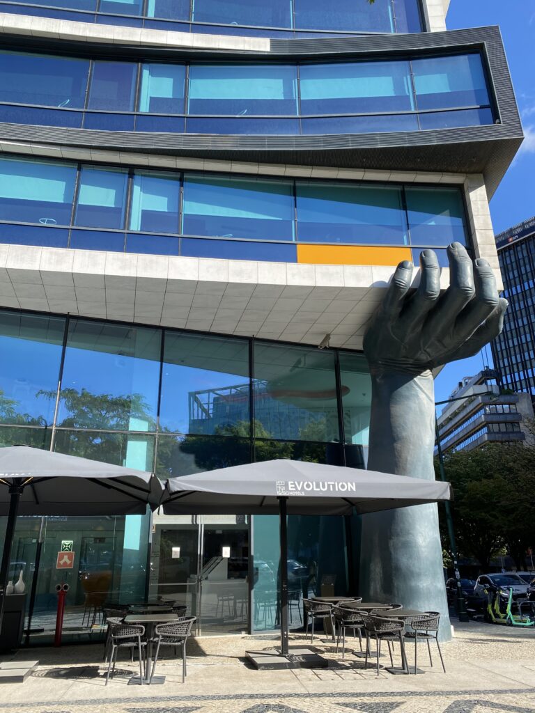 Facade of Lisbon hotel that has a large hand holding up one level