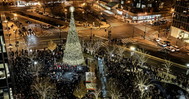 Tall Christmas tree in Washington DC surrounded by a crowd and holiday lights