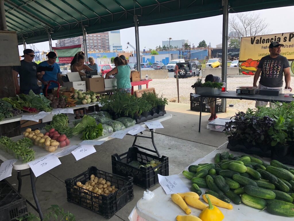 Vendors at tables at a farmers markets in Baltimore