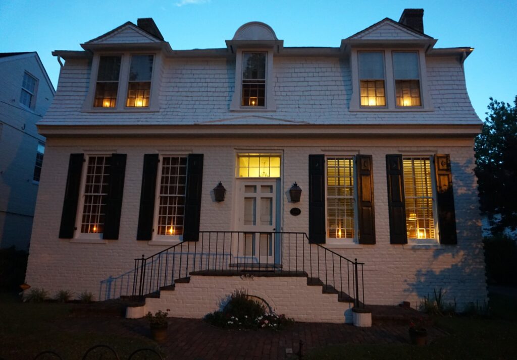 Historic colonial-style home at night with lights on inside on a weekend escape in Cambridge Maryland