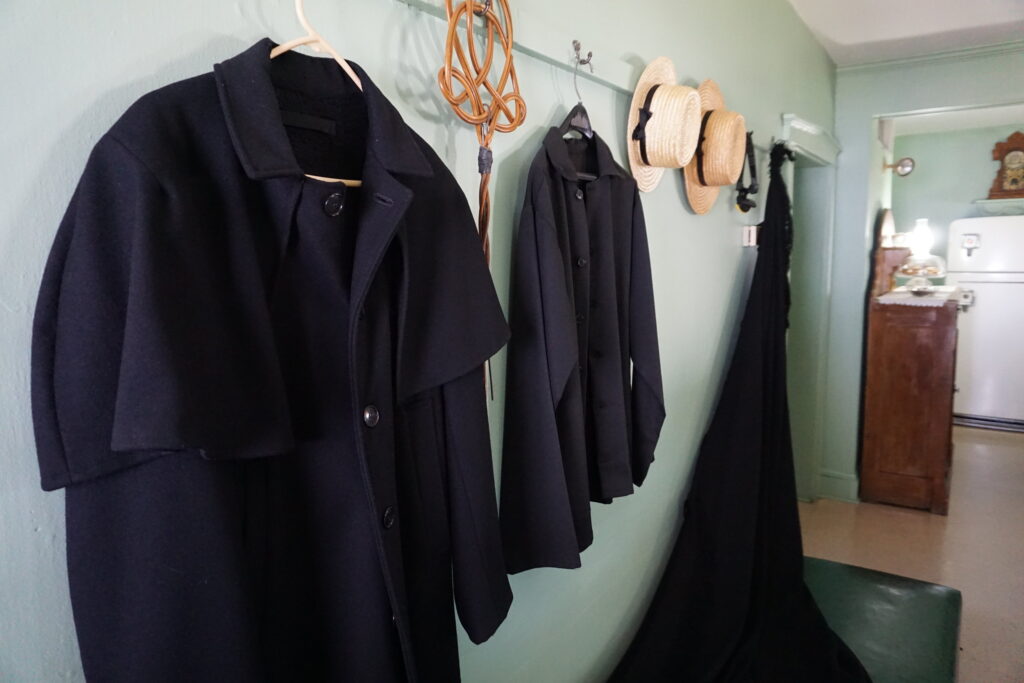 Amish coats hanging on a coat rack inside an Amish home