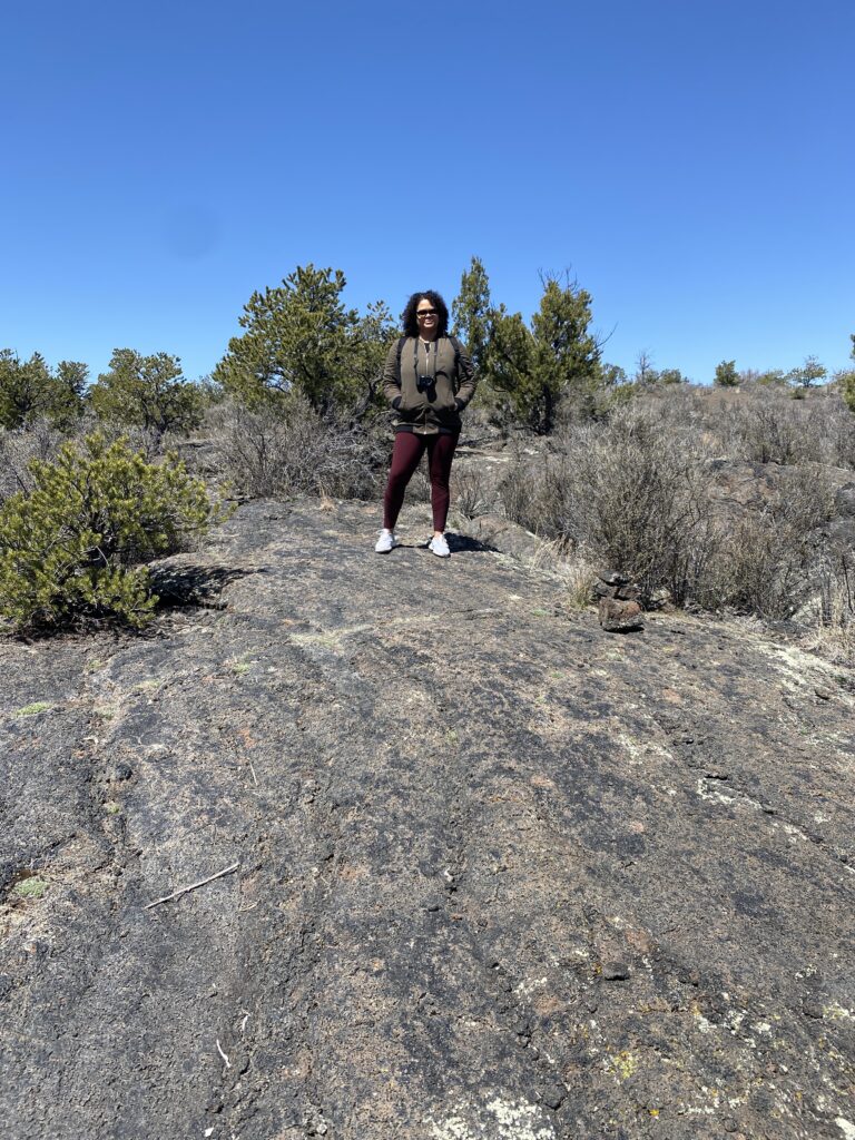 Woman standing on a hill of black hardened lava