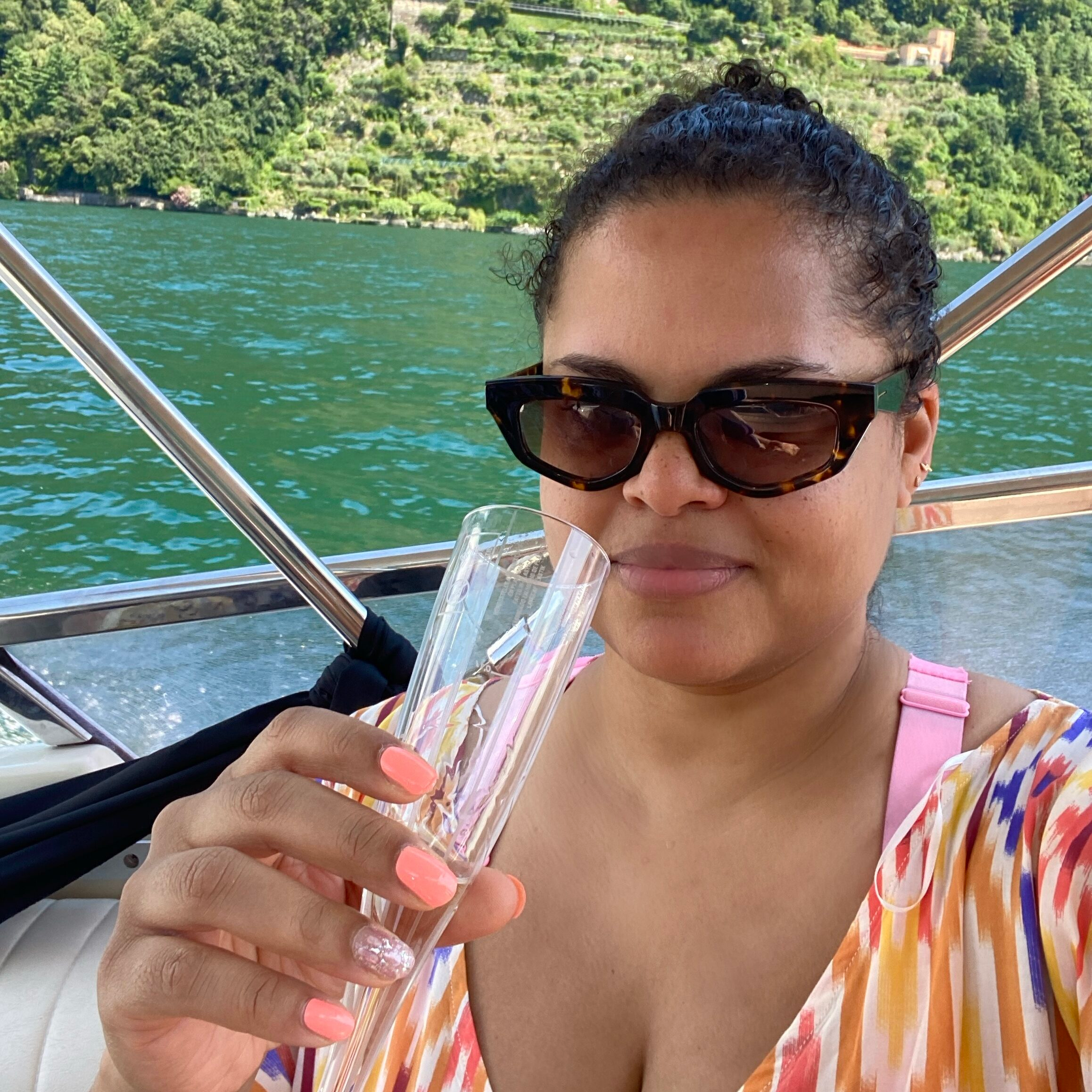Selfie of woman holding a champagne flute on a boat