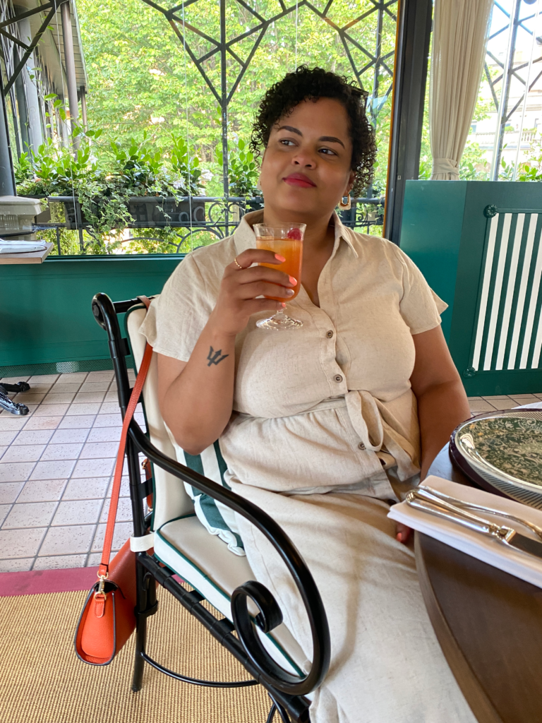 Woman sitting in restaurant chair holding a cocktail