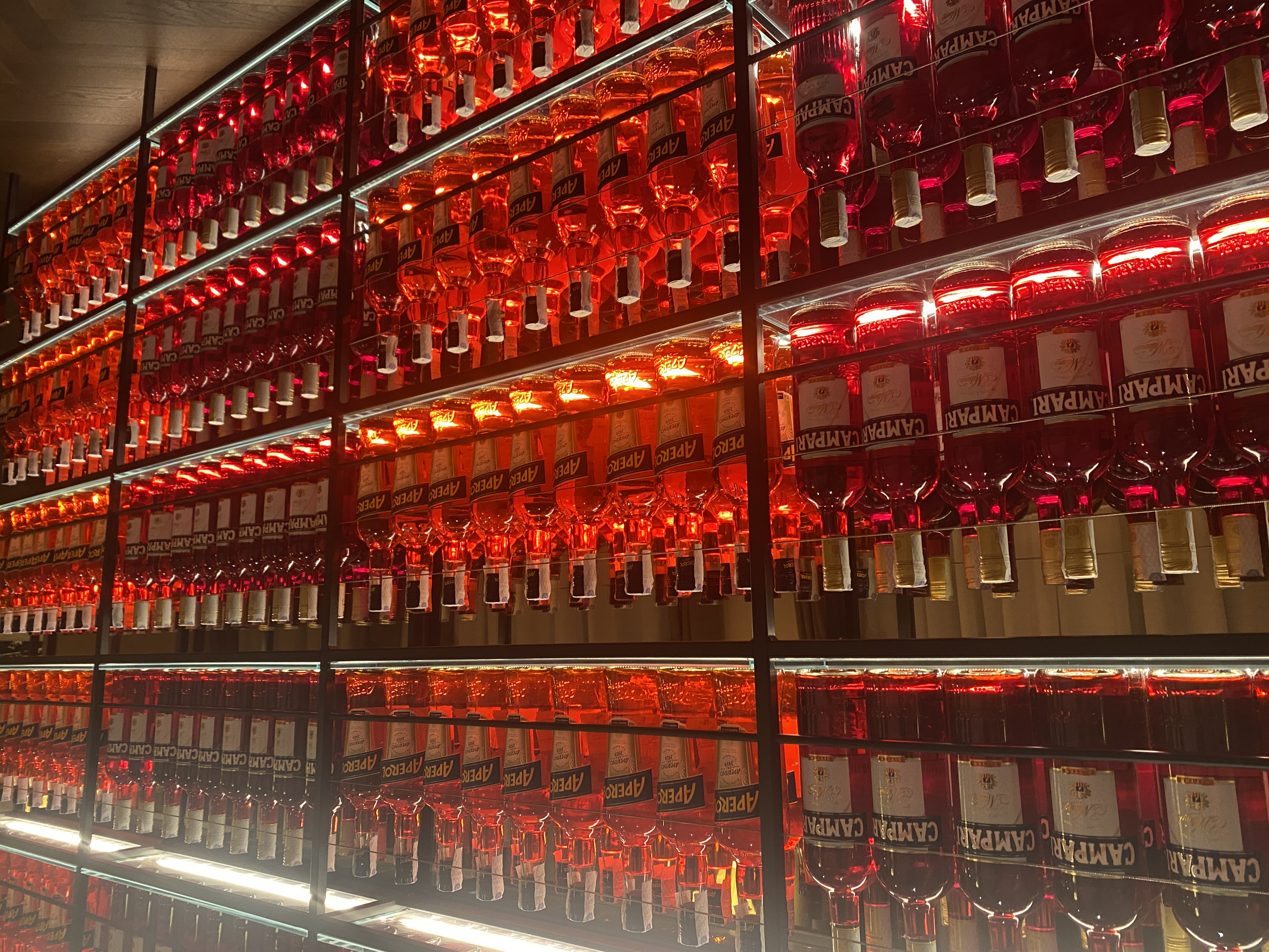 Shelves full of Aperol and Campari bottles
