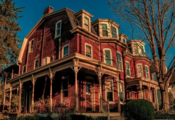 Large brick mansion surrounded by bare trees
