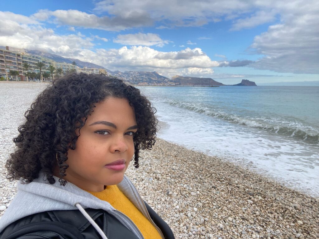 Woman taking selfie in on a white pebble beach in the Spanish Mediterranean town of Altea