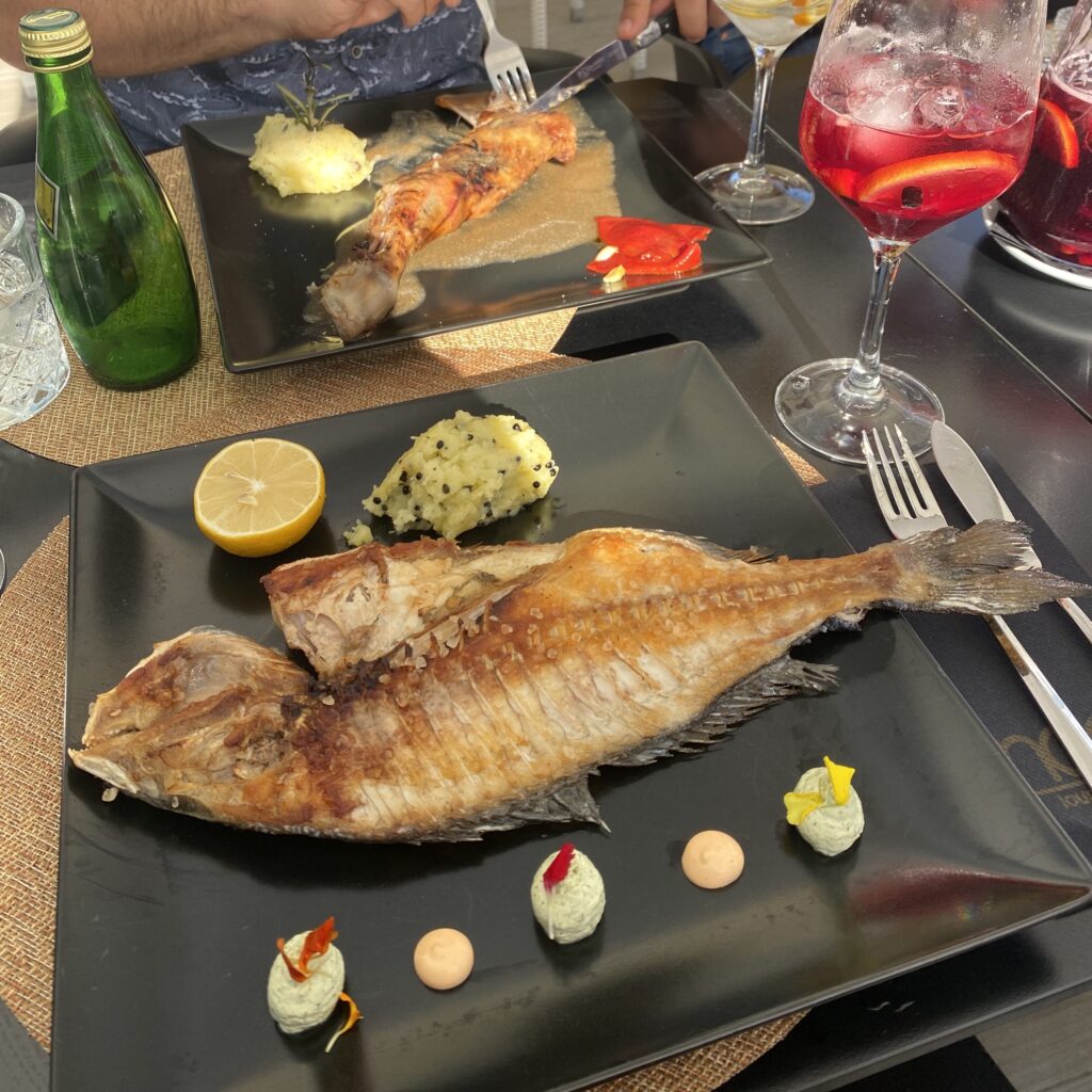 Whole fish on a plate at an outdoor restaurant