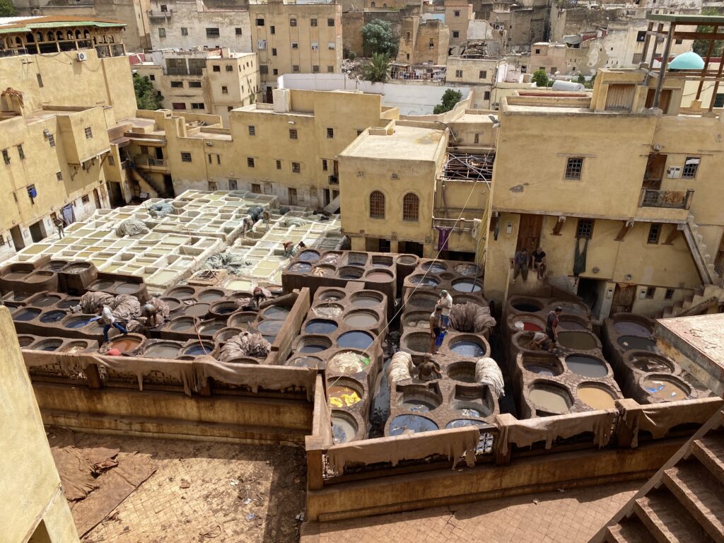 Honeycomb stone vats with workers dying animal skins in Fes Morocco