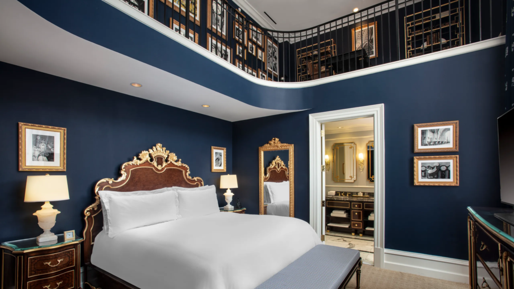 Elegant Waldorf Astoria guest room with two levels, blue walls, and opulent details