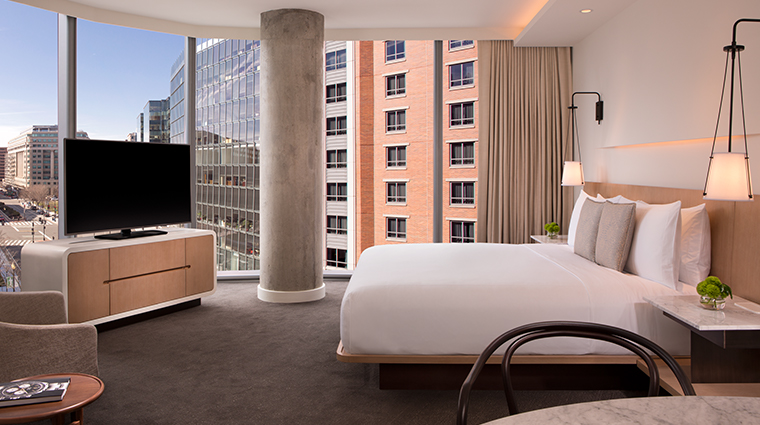 Guest room of The Conrad hotel in Washington DC with a bed, television, and wide view of downtown Washington DC