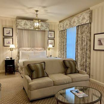 Hotel room with bed and couch with coffee table and elegant decor