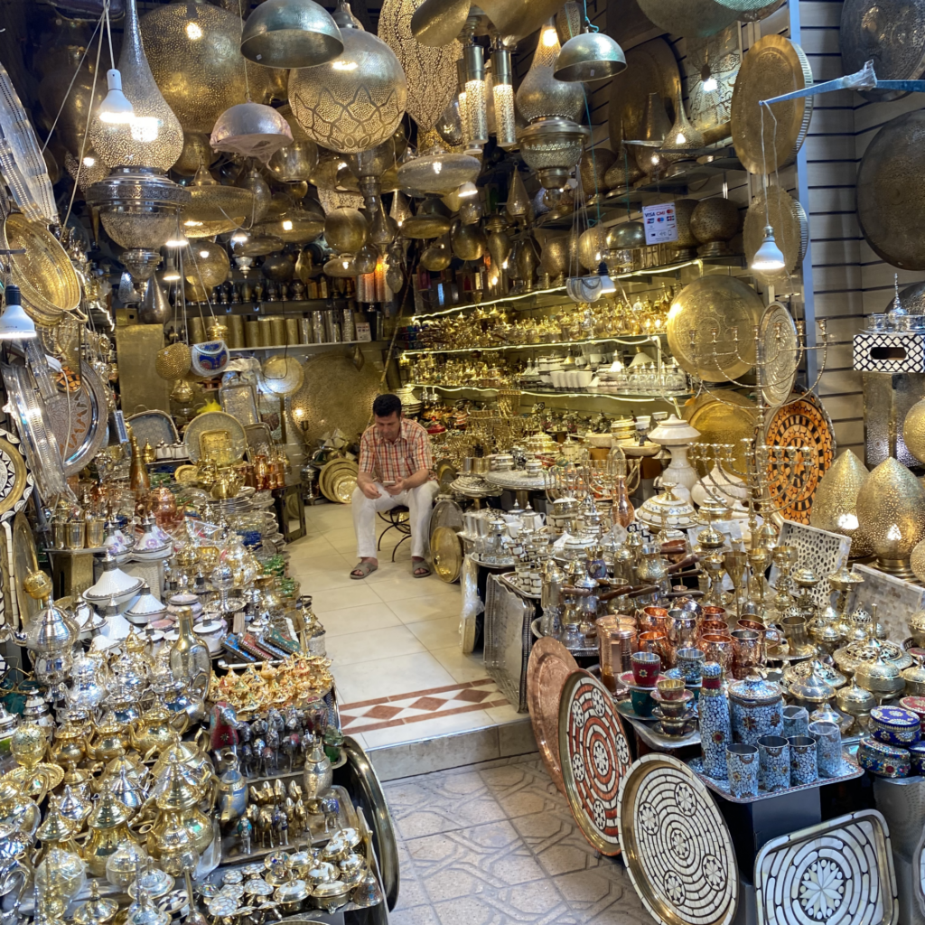 Vendor in a Morocco medina with lanterns and other metalwork on display