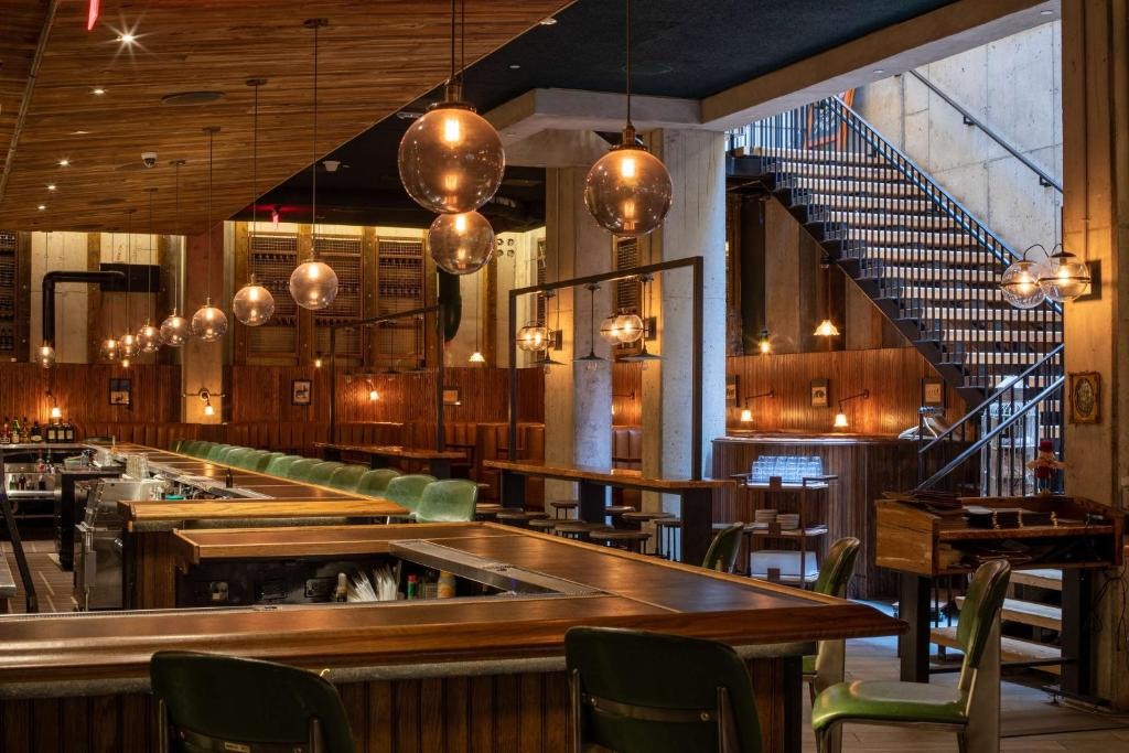 Bar and dining area of Motto by Hilton hotel in Washington DC with bar in foreground and staircase behind it