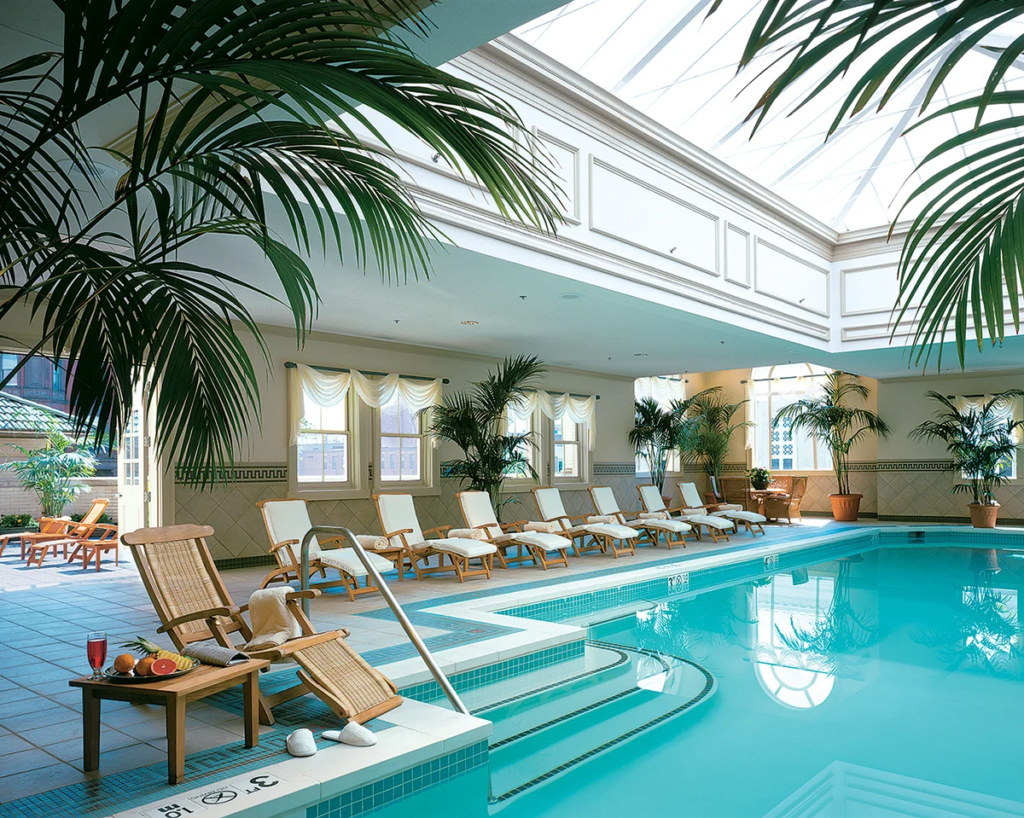 Indoor pool surrounded by tropical trees and lounge chairs