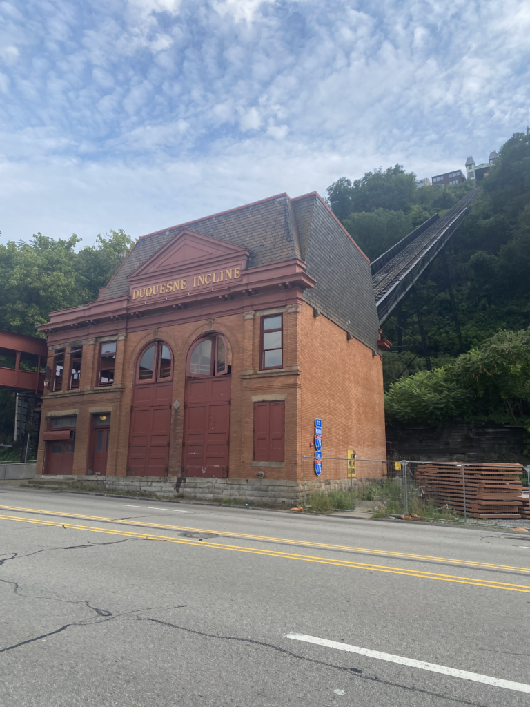 Historic brick building below a cable car rail up a hill in Pittsburgh Pennsylvania